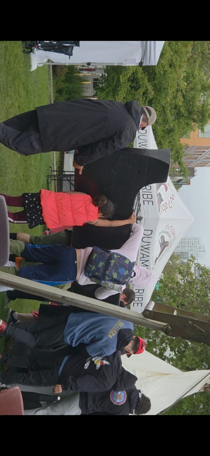 Children working on the canoe at the Duwamish Tribe tent, NW Folklife