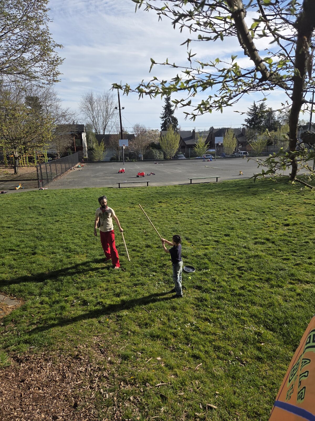 A child working with a stave on the open grass